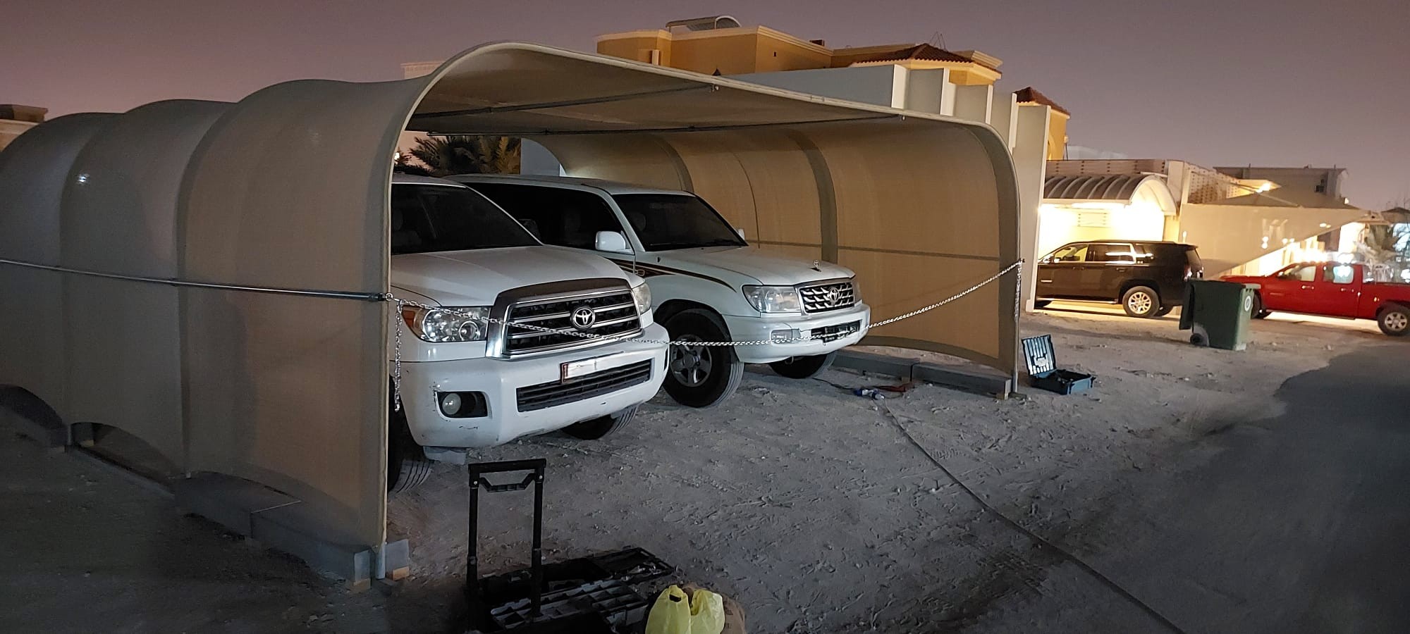 Large carport protecting two SUVs at night